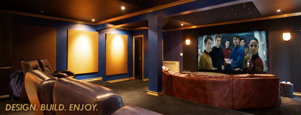 Basement home theater with a bar, blue walls, and a big screen