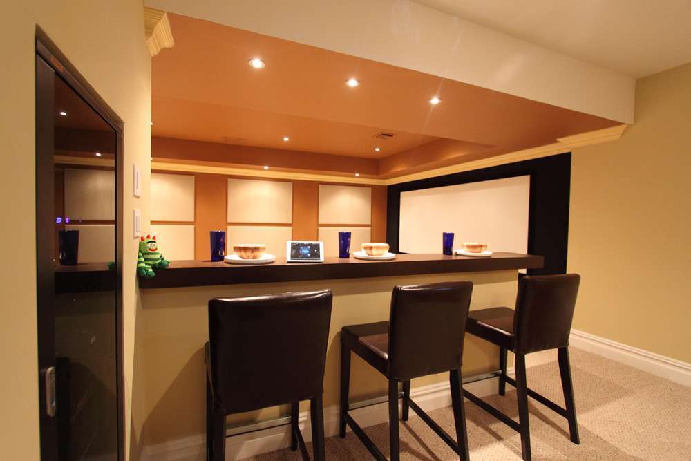 Basement theater bar with stools and a big screen