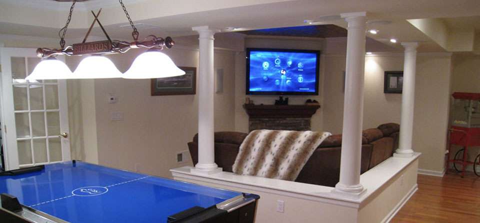 Finished basement game room with an air hockey table, a pool table light and a TV on the far wall