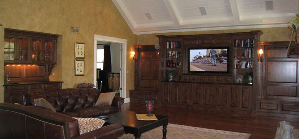 Family room with a high ceiling, leather sofas, and a TV in a wood cabinet
