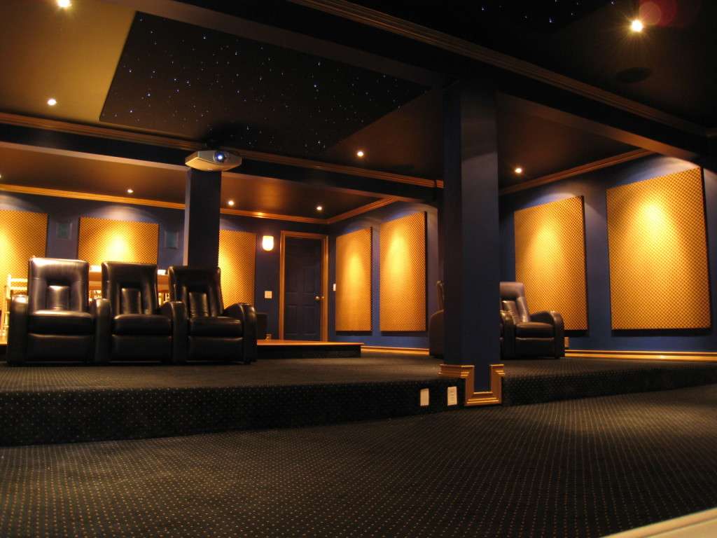 A basement theater with tiered seats and warm wall lights.
